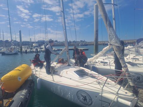 un groupe d'étudiants s'affaire dans un voilier au port